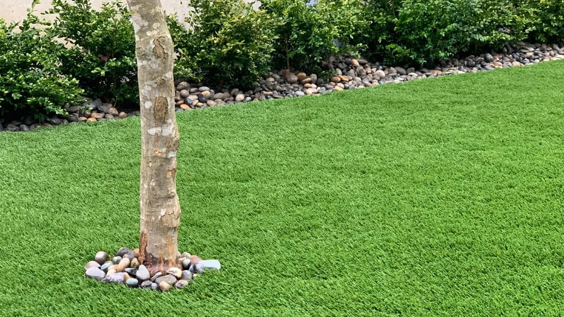 detail of low maintenance backyard installation with artificial lawn